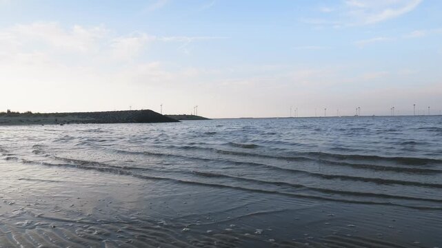 Low tide at Dutch coast with offshore wind turbines