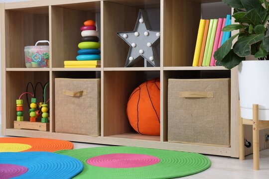 Shelving unit with toys, books and decor in child's room, closeup