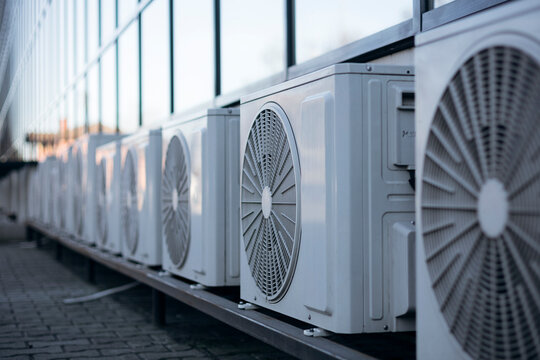 Outdoor air conditioning units mounted on building facade wall.