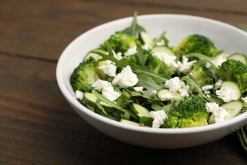 Obraz premium Tasty green salad with cream cheese on wooden table, closeup