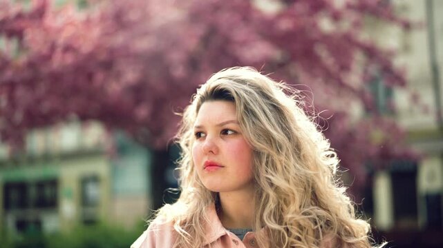 Young woman posing in soft spring light outdoors, natural beauty portrait, lifestyle video in Czech Republic, Europe, commercial use
Young woman with curly hair looking at camera outdoors, natural lig