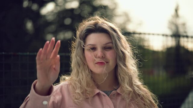 Young woman posing in soft spring light outdoors, natural beauty portrait, lifestyle video in Czech Republic, Europe, commercial use
Young woman with curly hair looking at camera outdoors, natural lig