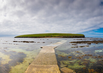 Vue panoramique de l'île Brough of Birsay sous un ciel nuageux depuis le bout du chemin immergé qui y mène, nord de l'Ecosse © Pascal