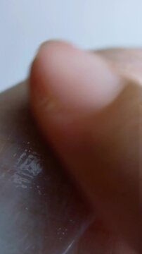 Applying white cream thoroughly and evenly all over hand skin. Close up view showing hand skin texture, moisturizing concept for smooth and healthy skincare routine on clean background.