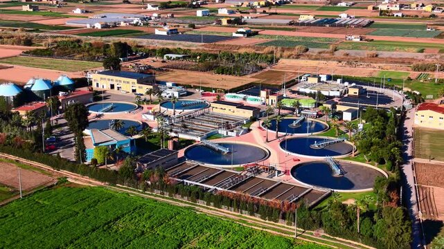 Environmental infrastructure with water purification tanks and large photovoltaic arrays in a rural setting. Solar powered sewage treatment plant with circular clarifiers.