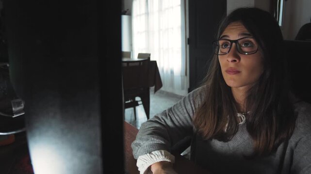 Video of a focused young woman working on her computer at home. Hybrid work and remote productivity lifestyle concept.
