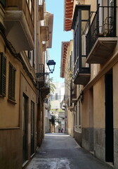 Naklejka premium Typical narrow alley in Palma's old town with Mediterranean facades and shutters