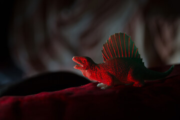 Plastic toy Green Dinosaur standing on a red carpet © VectorDot