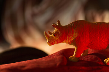  Plastic toy rhinoceros standing on a red carpet © VectorDot