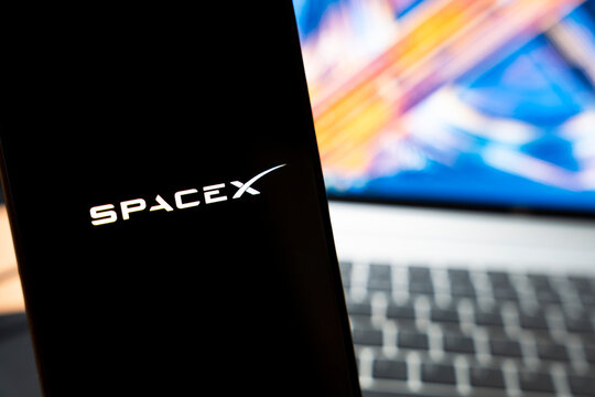 Warsaw, Poland - May 13, 2026: Close-up of a smartphone displaying the SpaceX logo with a colorful blurred background and laptop keyboard, showcasing technology and innovation in modern communication