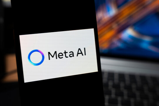Warsaw, Poland - May 13, 2026: Close-up of a smartphone displaying the Meta AI logo on the screen, with a blurred laptop background representing modern technology in a digital workspace.