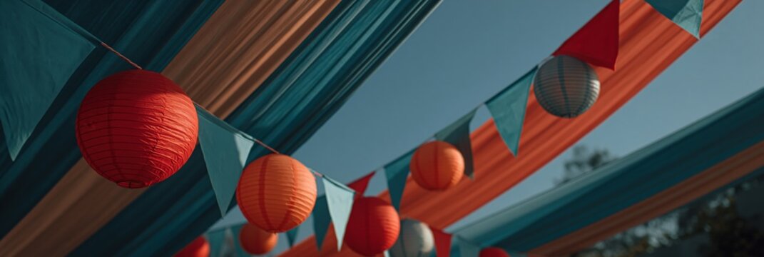 Paper lanterns and bunting hanging beneath striped fabric canopy
