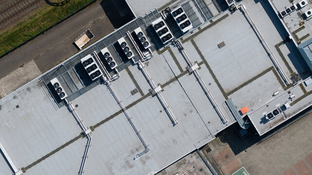 Aerial view of industrial HVAC systems and ventilation units on a large flat roof near railway tracks in Utrecht, Utrecht, Netherlands.