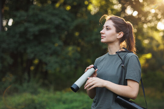 Young woman has a spyglass while standing in a forest at summer