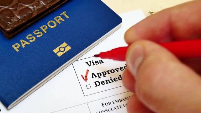 Person Checking Visa Approved Box on Application Form Next to Passport