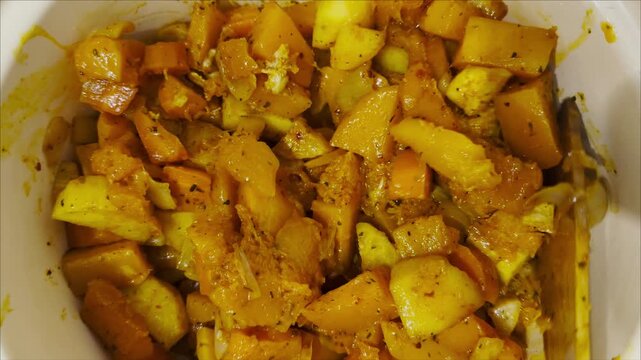 Top view on female hand stirs with spatula stew in pot on stove at kitchen. The mixture of meat and vegetables cooks evenly releasing rich aroma. Focus on appetizing appearance of hearty homemade dish
