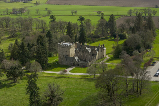 Aerial view of Drum Castle, Garden and Estate National Trust for Scotland featuring the historic stone tower and lush green lawns in Drumoak, Scotland, United Kingdom.