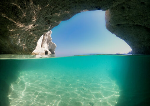 Split-level sea cave with turquoise water and blue sky
