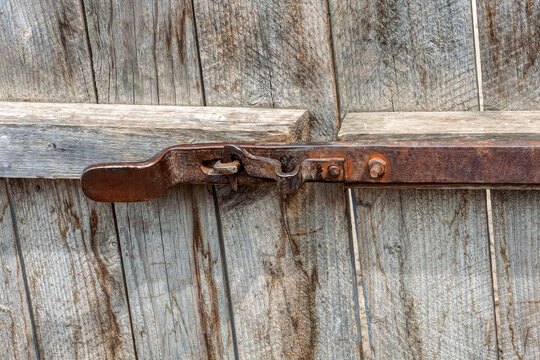 old rusty metal Weathered Iron Latch on a Rustic Wooden Barn Gate of a farm building