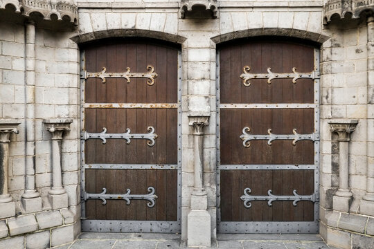 Weathered wooden doors with decorative iron hinges
