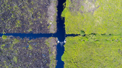 Naklejka premium Aerial View of Peatland Drainage Canal Intersection with Canal Blocking Structure