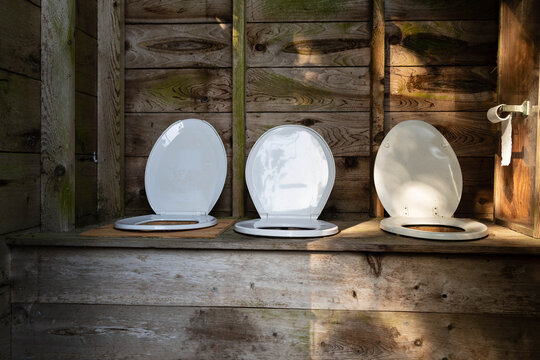 Outdoor outhouse with room for several customers - three toilet seats