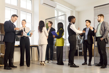 Obraz premium Businesspeople team meeting discussing strategy in office. Colleagues share a handshake, showing collaboration and communication in a modern office. Concept shows teamwork and business networking.