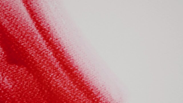 Close up of red watercolour drawing paints on paper. Artist draws with a brush, liquid analog effects for background with copy space for text in center. 