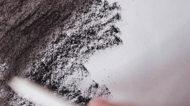 close up of charcoal pencil drawing blending on textured paper. slow motion footage. Background video can be used as overlay. doodling hatching