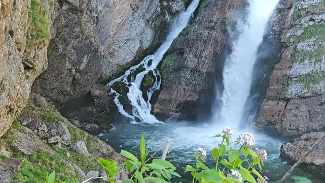 Stunning cinematic shot of Slap Savica waterfall in Slovenia. Crystal clear water cascading from limestone cliffs into an emerald pool. 4K 60fps high frame rate footage for travel and nature projects.