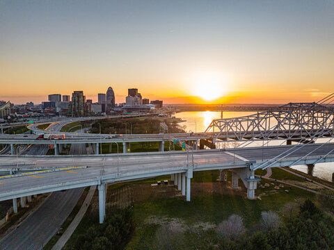 Aerial view of the Louisville skyline, complex highway interchanges, and the Ohio River during a golden sunset Louisville, Kentucky, United States.
