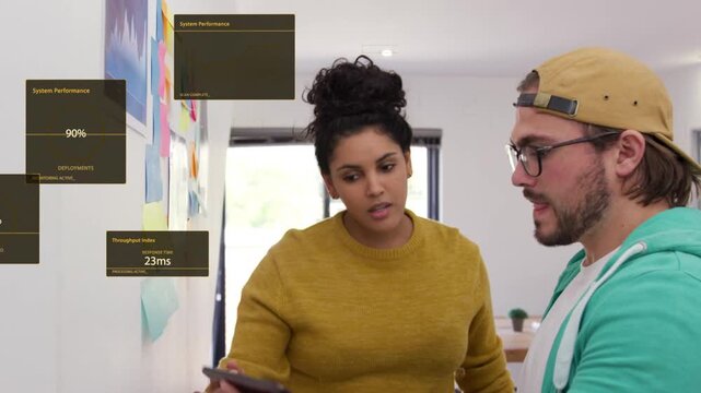 Woman pointing at notes wall and man lifting tablet, starting tech overlays and aligning data
