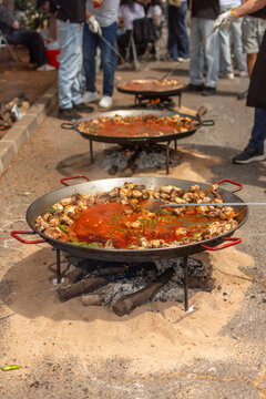 Close up of traditional paella cooking over wood fire