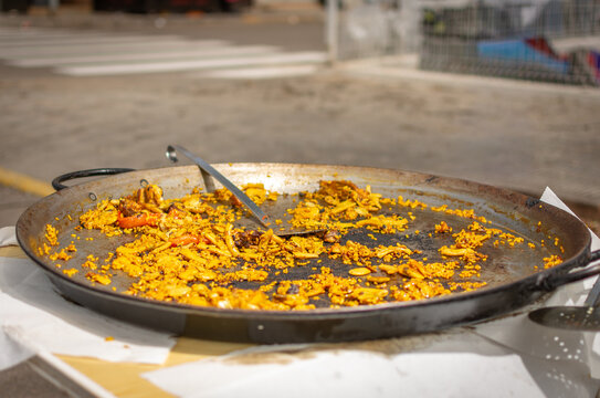 Empty Valencian paella pan with leftovers and metal spoon