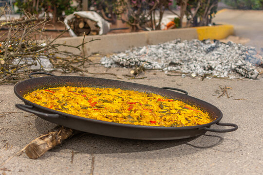 Traditional Valencian paella on ground after wood fire cooking