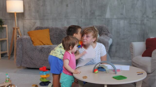 Mother tries to work while children play around her