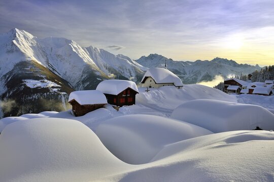 Deep snow-covered mountain village, Bettmeralp with chapel Maria zum Schnee in the evening light, Canton Valais, Switzerland
