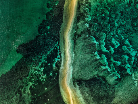 Aerial drone view of Lakdayan Sandbar near Coron Island, Philippines, featuring a curved tropical sandbar, turquoise coral reefs, crystal clear ocean water and a remote island landscape in Palawan.