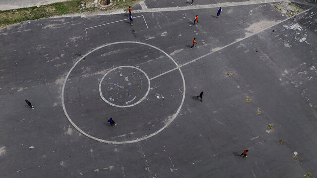 Aerial view of people playing on an asphalt sports court with circular markings at the National Stadium Surulere Lagos, Lagos, Lagos, Nigeria.