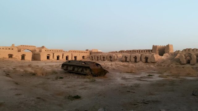 qala-i-shahrara fort kabul hilltop ruins. abandoned soviet armored vehicle in desert landscape. ancient mud-brick architecture, military remnants, and historical viewpoint.