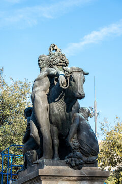Detailed shot of the majestic "Barcelona" sculpture by Frederic Mar&egrave;s featuring a man and a bull against a clear blue sky.