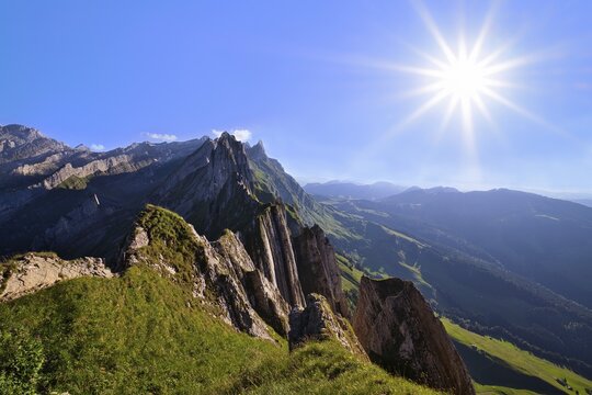 View of the Alpstein mountains in Appenzell, direct backlight with sun star in a cloudless sky, Canton Appenzell Innerrhoden, Switzerland