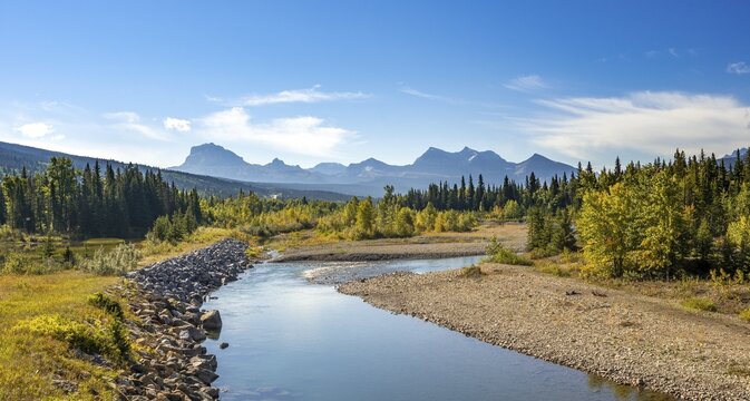 View over river to mountains, autumnal deciduous trees, Rocky Mountains at Glacier National Park, Kennedy Creek, Glacier County, Montana, USA