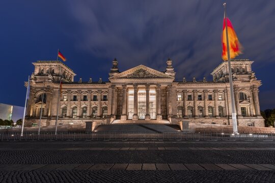 Reichstag with waving German flag, night photograph, government district, Berlin, Germany