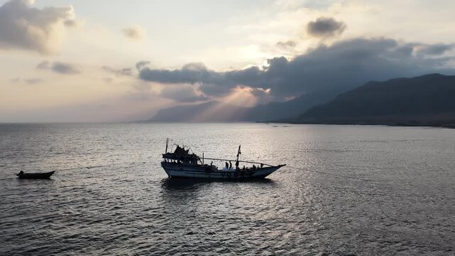 Traditional fishing boat sailing on a calm sea at sunset, Socotra island