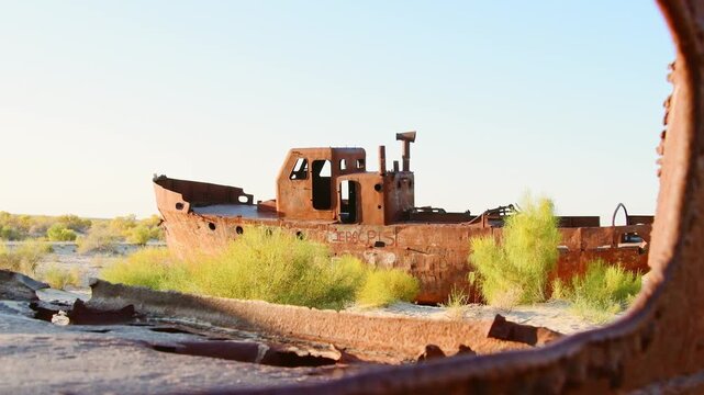 Moynaq Ship Graveyard Uzbekistan sunrise. Rusted fishing vessels stranded in the Aralkum Desert. Environmental disaster memorial showing the dried Aral Sea and lost maritime heritage in Muynak.