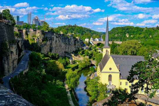 Panoramic Aerial View of Luxembourg City Grund District with Saint John Church Spire, Alzette River Valley, Bock Cliffs and Modern Kirchberg Skyline, UNESCO Site