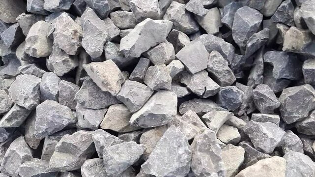 camera slide over close up of granite gravel stones or aggregate crusher stone on the ground used in building concrete construction.