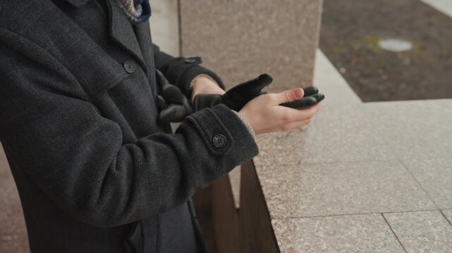 Man adjusting gloves and scarf, ready at granite ledge focused gaze, buttoned overcoat, cold urban morning mood, closeup of hands and texture, cinematic composition showing creator resolving to begin