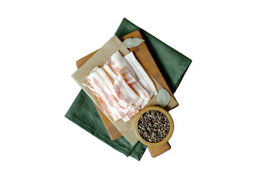 Raw bacon on wooden cutting board on brown background. Streaky brisket slices, fresh thin sliced bacon. Top view